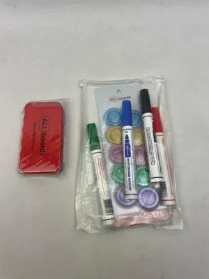 A red whiteboard eraser and a package of whiteboard markers and magnets are shown.
