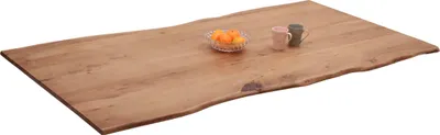 A wooden tabletop with a live edge, shown from a slightly elevated angle against a white background. Two mugs and a bowl of fruit are placed on the tabletop.