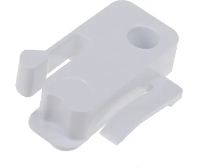 A white plastic stopper for a freezer compartment flap.