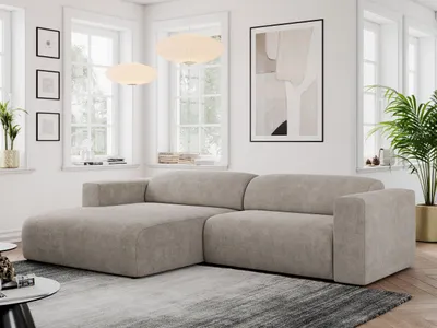 A modern living room with a beige sectional sofa, large windows, and artwork on the wall.