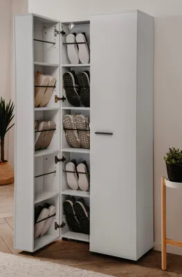 A white shoe cabinet with its doors open, displaying shoes on shelves.