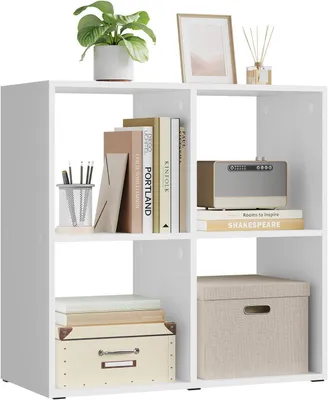 A white cube shelf unit with various items placed on its shelves.