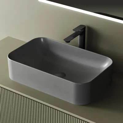 A dark gray rectangular vessel sink with a black faucet on a beige countertop.