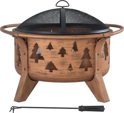 A copper-colored fire pit with tree cutouts and a black mesh screen lid, shown on a white background with a poker tool below.