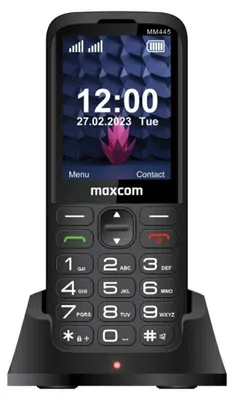 A black Maxcom Comfort MM445 mobile phone is shown in its charging dock.