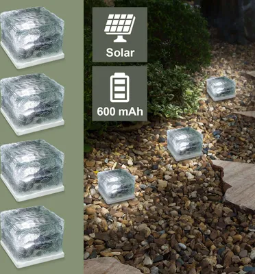Solar-powered glass cube lights placed on a gravel path in a garden setting.