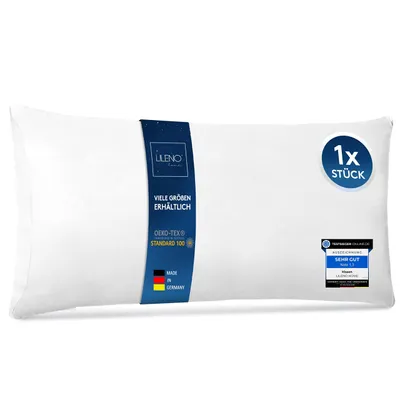 A white pillow on a white background, with product information labels attached.