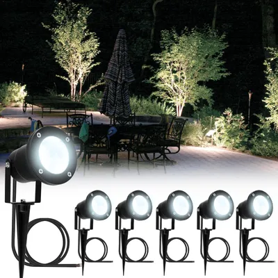 Outdoor patio scene at night, illuminated by spotlights.