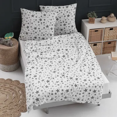 A bed with star-patterned bedding in a room.