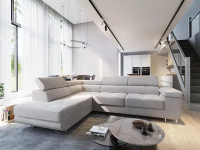 A modern living room with a large sectional sofa, coffee table, and stairs leading to an upper level.