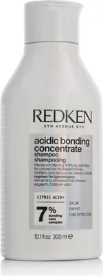 A white bottle of Redken shampoo against a white background.