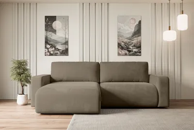 A modern living room setting with a sectional sofa, artwork, and pendant lights.