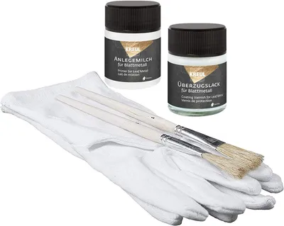 A kit for applying leaf metal, including two bottles of liquid, gloves, and brushes, laid out on a white background.