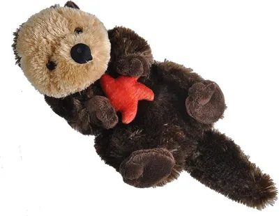 A plush toy sea otter lying on its back, holding a red starfish.