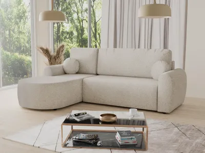 A sectional sofa in a living room setting with large windows overlooking trees.
