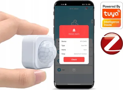 A hand holds a small white motion sensor next to a smartphone displaying a motion alarm notification from the Tuya app.