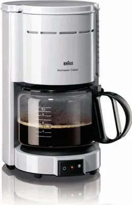 A white Braun coffee maker with a glass carafe filled with coffee, shown on a white background.