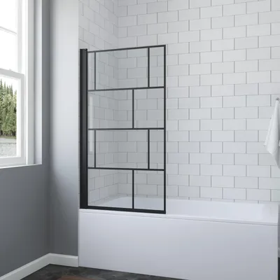 A shower screen for a bathtub in a bathroom with white tiled walls.
