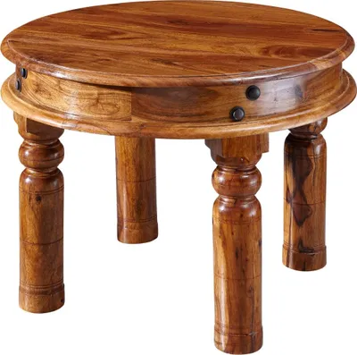 A round wooden coffee table with carved legs, photographed against a white background.