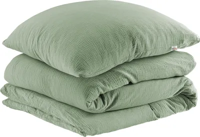 A stack of folded green bedding, including a pillow and a duvet cover, on a white background.