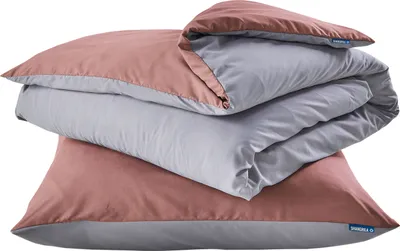 A stack of folded bedding, including a pillow and a duvet, in alternating pink and gray colors.