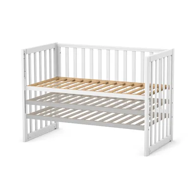 A white baby crib with a wooden slatted base, shown from a slightly elevated side angle against a white background.