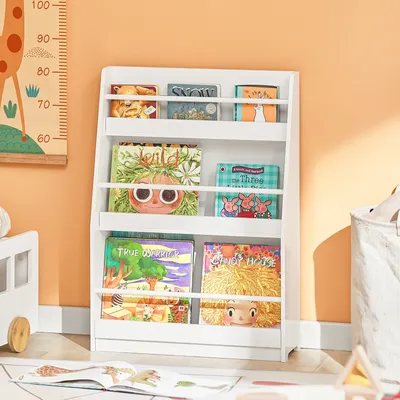 A white children's bookshelf filled with colorful books, placed in a room with an orange wall and a giraffe height chart.