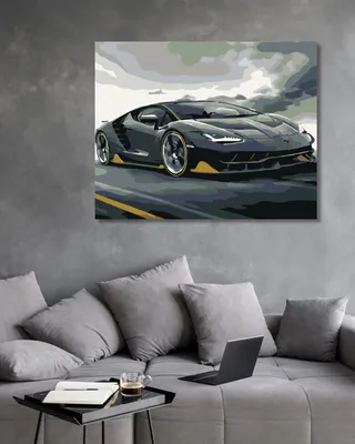 A painting of a black Lamborghini is displayed on a wall above a gray sofa with pillows and a coffee table with a book and a cup of coffee.