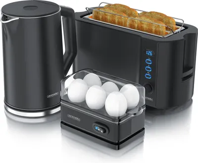 A black electric kettle, a black toaster with toast, and a black egg cooker with eggs are arranged together on a white background.