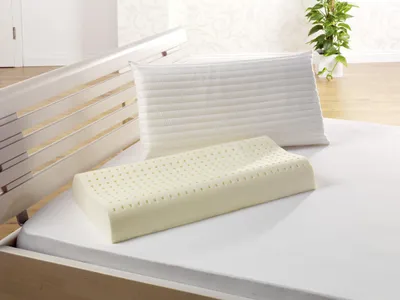 Two pillows on a bed with a wooden bed frame.
