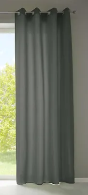 A dark gray curtain hanging in front of a window with trees visible outside.