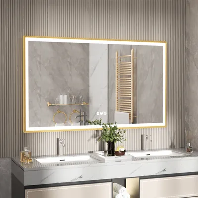 A modern bathroom vanity with a large LED mirror above it, featuring two sinks and gold accents.