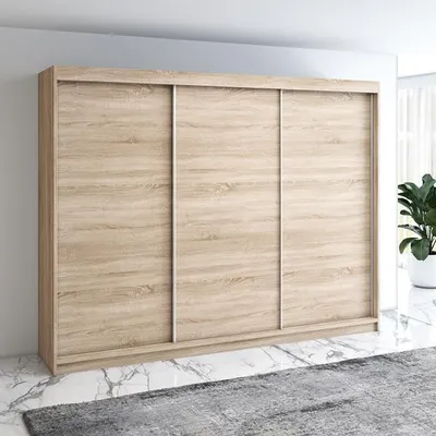 A modern sliding door wardrobe with a light wood finish is shown in a room setting.