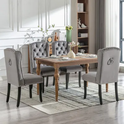 A dining room set with four chairs and a table, set on a rug.