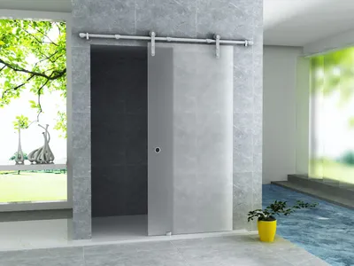 A modern bathroom with a frosted glass sliding door and a large window.