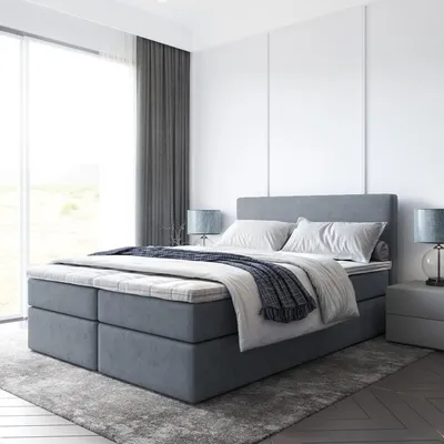 A modern bedroom with a large bed, bedside tables, and curtains.