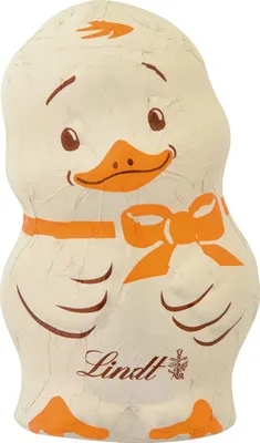 A white chocolate duckling candy wrapped in white foil with orange accents.