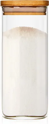 A clear, well-lit studio shot of a glass storage jar filled with a white granular substance, topped with a bamboo lid.