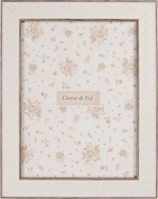 A white picture frame with a floral pattern inside.
