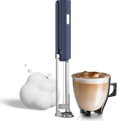 A blue and silver electric milk frother is shown next to a glass cup of coffee with foam.