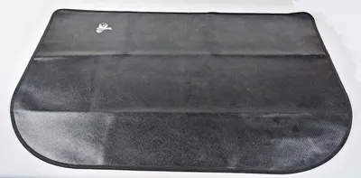 A black fire-resistant mat is laid flat on a white surface.