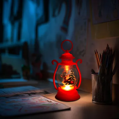 Produktbild von Weihnachtslaterne mit LED-Lichtern - Weihnachtsmann-Design - warmweißes Flackerlicht - batteriebetrieben mit 3 X LR44 - für Tischregal oder Fensterbank - rot - 16,5 X Ø7 Cm - 1 Stück [59719A], KI-generiertes Bild