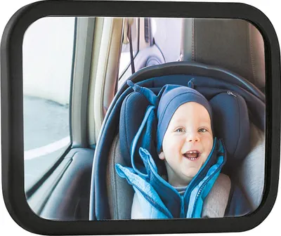 A baby in a car seat is reflected in a car mirror.