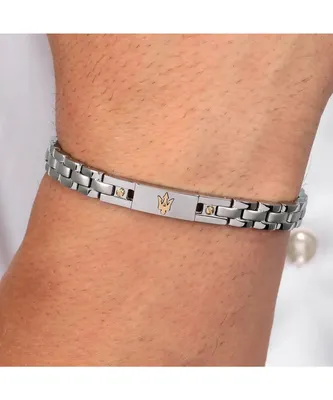 A close-up shot of a man's wrist wearing a silver bracelet with gold accents and a Maserati trident logo.