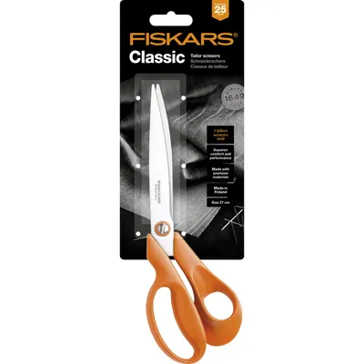 A pair of Fiskars Classic tailor scissors in orange and silver, presented in its retail packaging.