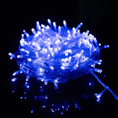 A close-up shot of a tangled ball of blue LED string lights against a black background.