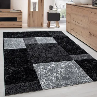 A modern living room with a rug, furniture, and decor.