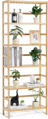 A tall, narrow, multi-shelf wooden bookcase filled with decorative items and plants.