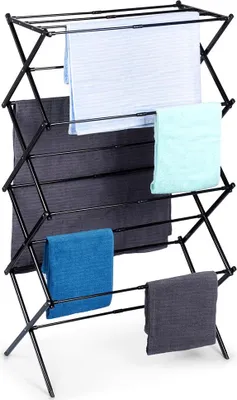A black collapsible drying rack with several towels draped over it.