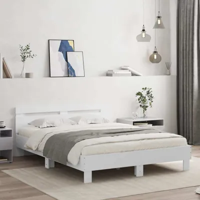 A white bed frame with a mattress and bedding in a minimalist bedroom setting.